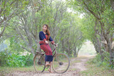 Young asian women sitting on an old bike in tribe dress .