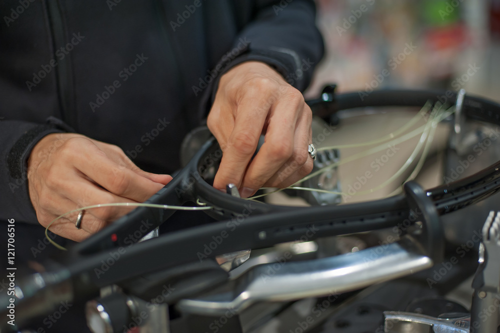 Stringing Machine. Close up of tennis stringer hands doing racket stringing in his workshop