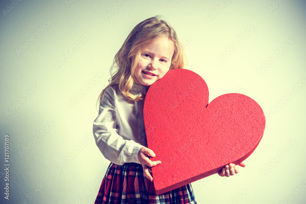 Beautiful smiling blond girl in a school uniform with a big red Beautiful smiling blond girl in a school uniform with a big red