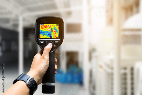 technician use thermal imaging camera to check temperature in fa photo