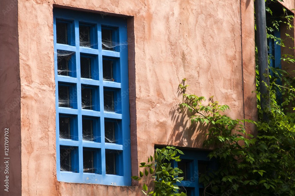 Pink facade of country house with blue windows