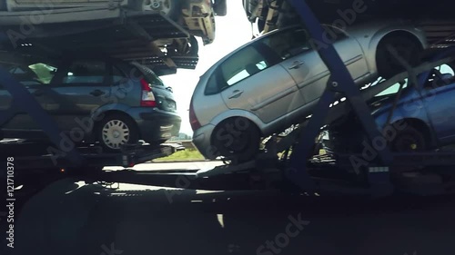 Passing by large car transporter delivery truck on the highway road, slow motion footage with lens flare and light leaks