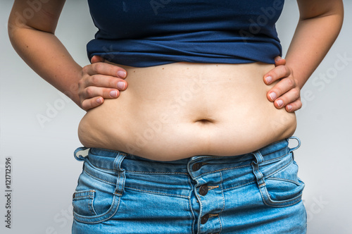 Overweight woman in jeans and fat on hips and belly