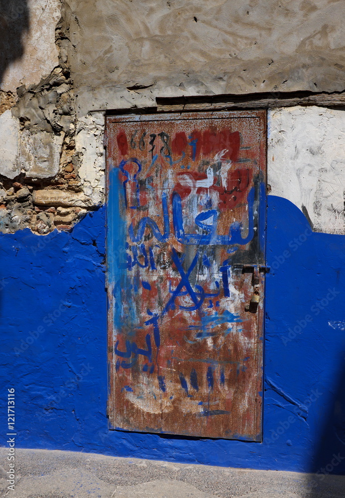 porte métallique rouillée sur vieille façade bleue