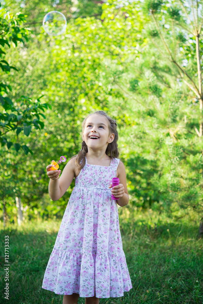 Girl on the lawn making soap bubbles Girl on the lawn making soap bubbles