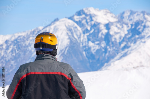 Wallpaper Mural Man in black coat and yellow helmet watch on mountain peaks on ski resort. Winter extreme sport concept. Copy space for advertising. Torontodigital.ca