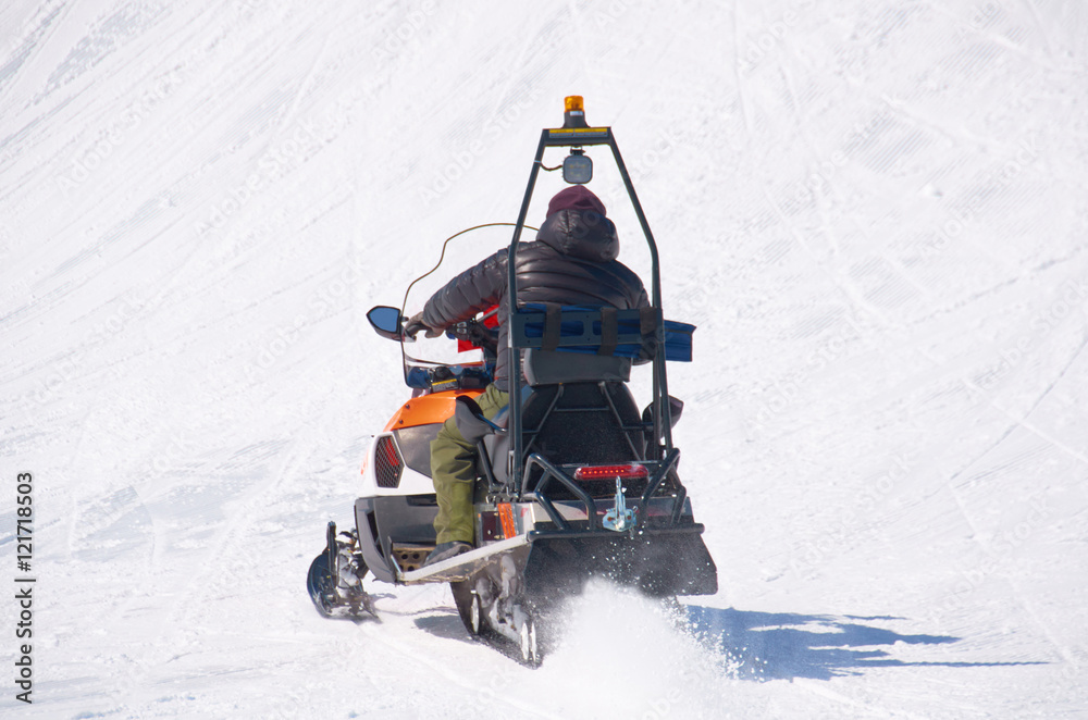 man drive snowmobile in mountains. ski resort staff. extreme driving with perfect winter landscape. Snow riding to the peak. man drive snowmobile in mountains. ski resort staff. extreme driving with perfect winter landscape. Snow riding to the peak.