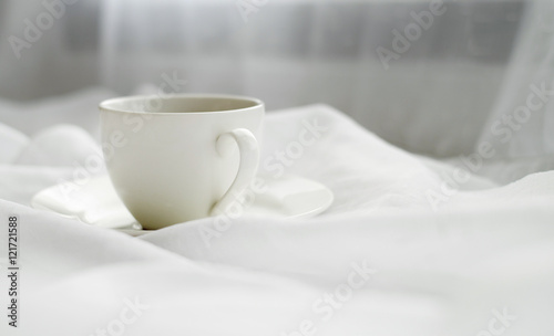 Cup on white fabric background