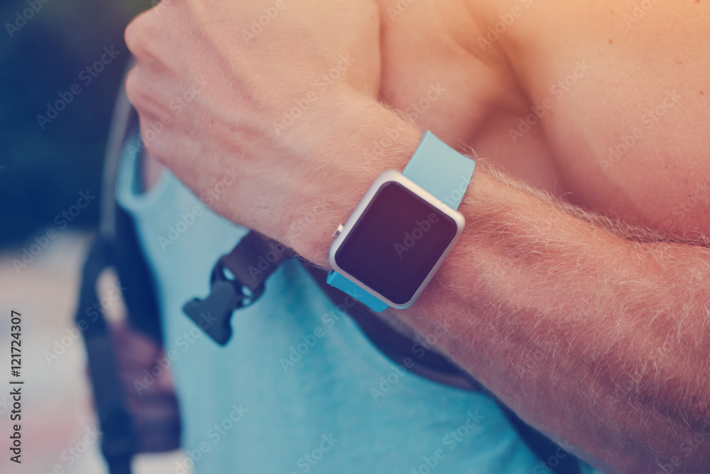 Man with backpack wearing smart watch on the wrist