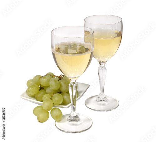 two glasses of sparkling white wine. green grapes on a white plate. isolated on white background