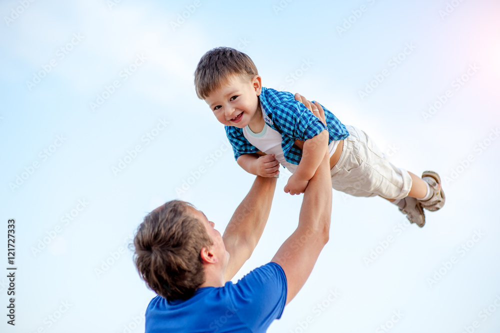 Man toss the boy up. Behind Ocean and clean sandy beach Man toss the boy up. Behind Ocean and clean sandy beach