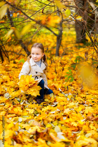 Little girl outdoors at autumn day