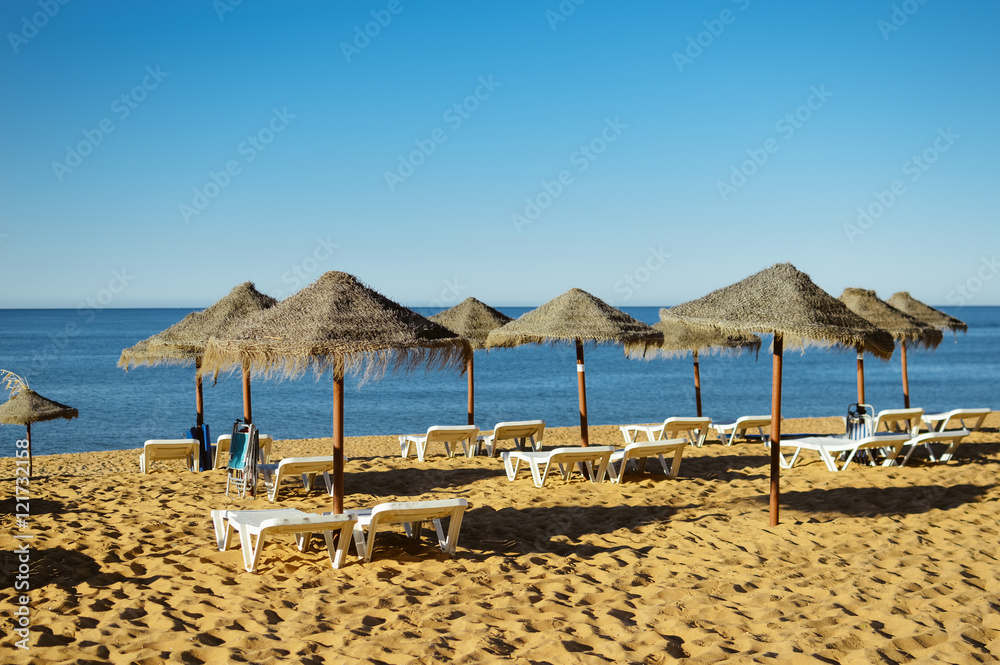 Blue sky and straw umbrella on a beautiful tropical beach background