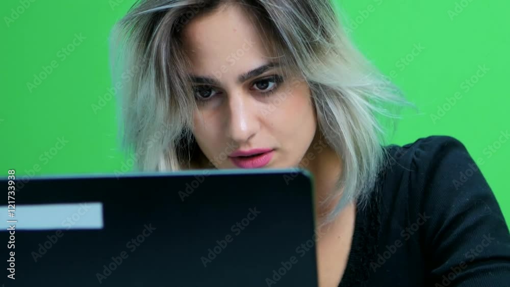 close up of girl sitting at table and working at a laptop. Green screen studio close up of girl sitting at table and working at a laptop. Green screen studio
