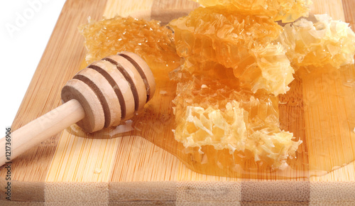 honeycomb honey with diper on a wooden cutting board, white background photo