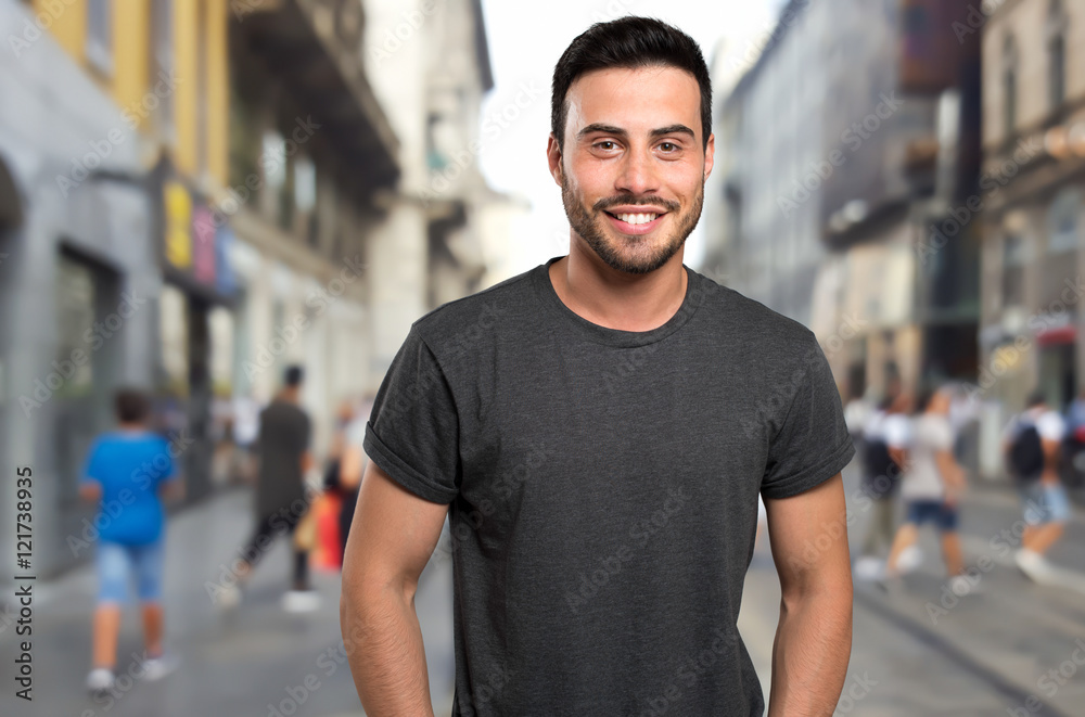 Young male fashion model walking in street