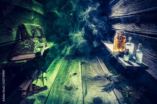 Witch hut with potions, scrolls, books and blue, green smoke with copy space for Halloween