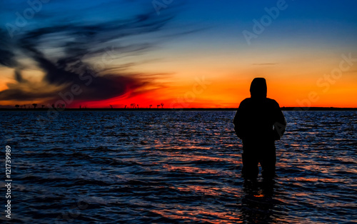 Colorful sunset and fisher silhouette