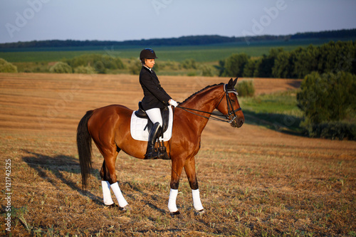 Portrait of equine sportswoman jumping on a hors © serkucher