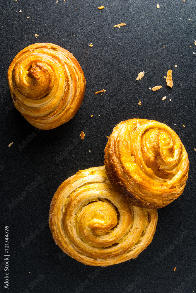 Fototapeta premium Freshly baked cinnamon rolls on a black background
