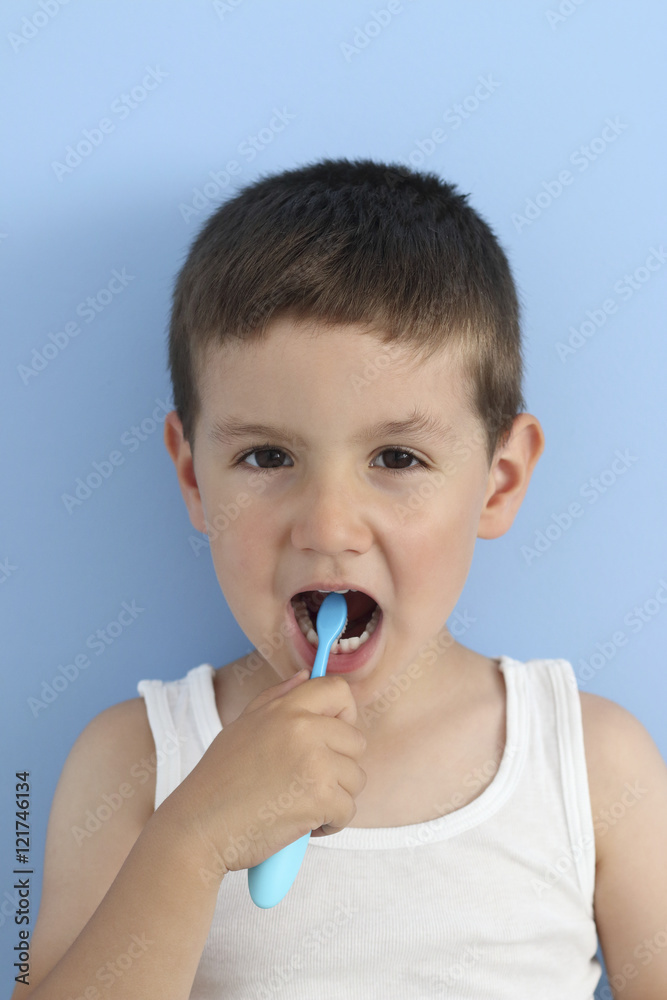 kid brushing his teeth with a toothbrush in a blue background
kid brushing his teeth with a toothbrush in a blue background