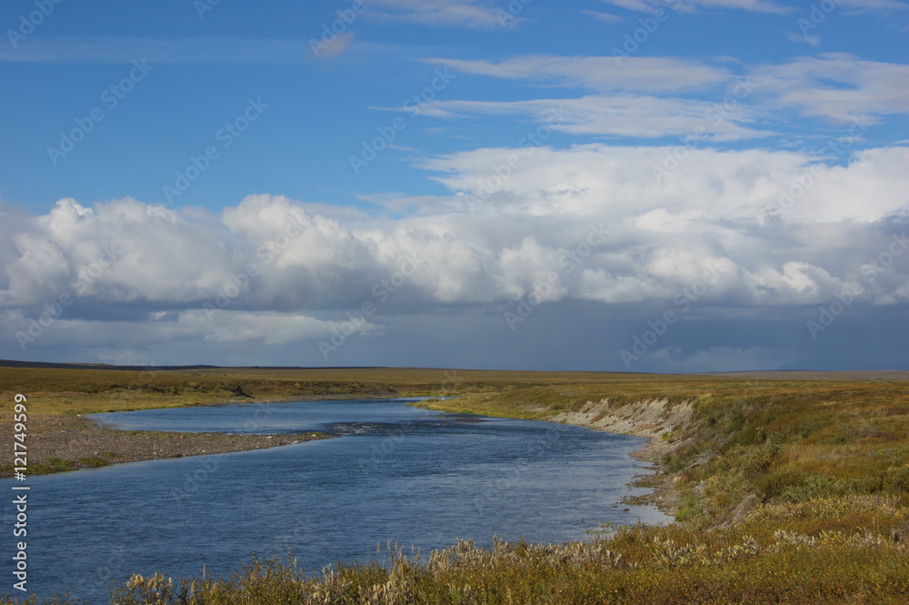 Small Usa river flows amongst the autumn tundra. Journey through the Polar Urals.