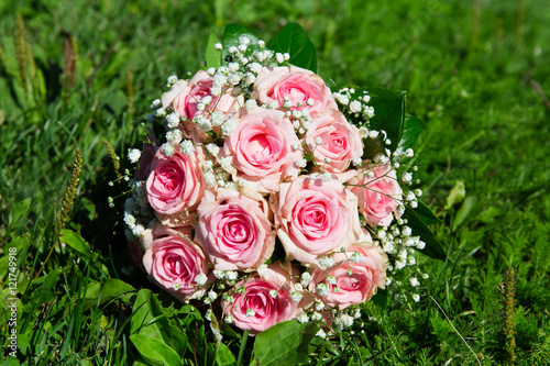 Pink roses bouquet on green grass