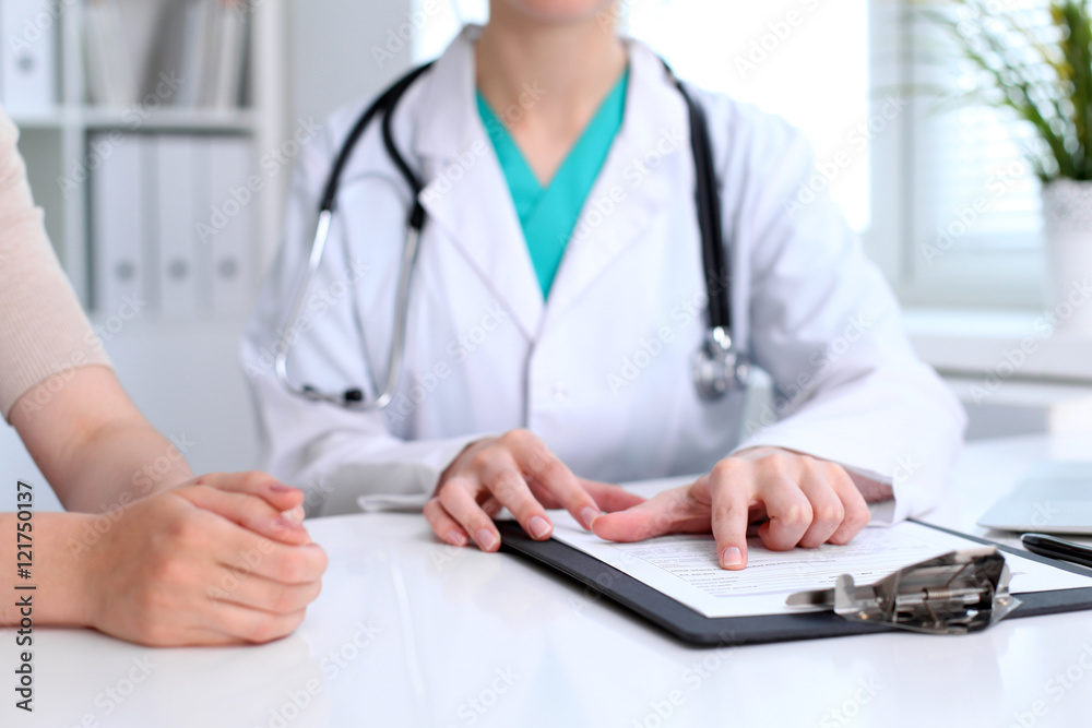 Doctor and patient are discussing something, just hands at the table Doctor and patient are discussing something, just hands at the table