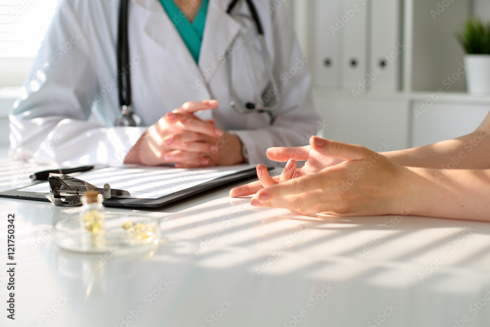Fototapeta premium Doctor and patient are discussing something, just hands at the table
