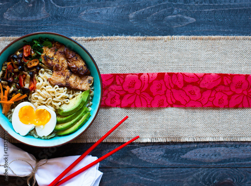 Japanese noodles bowl with chicken, carrots, avocado photo