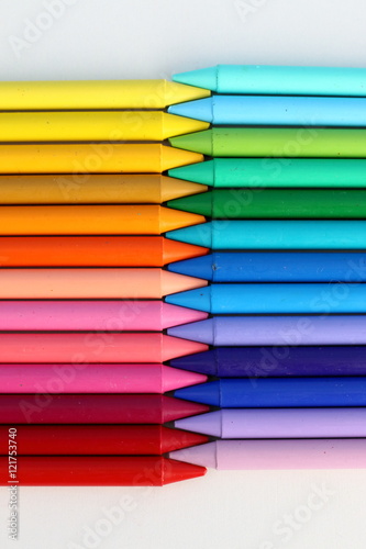 colorful pattern of cold and warm color crayons in a white background