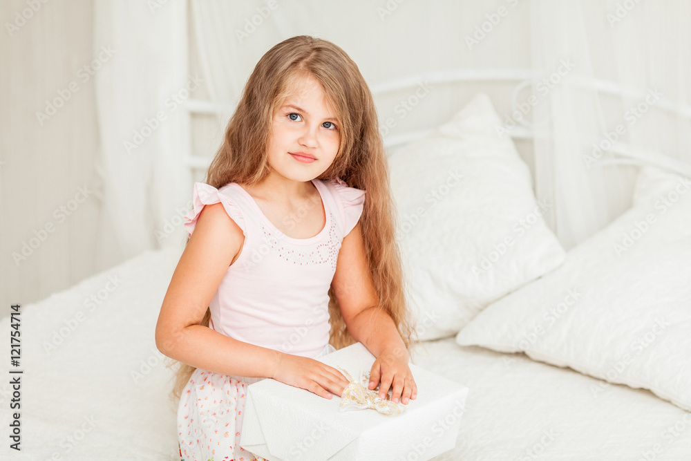 Morning. Child girl opening a gift
