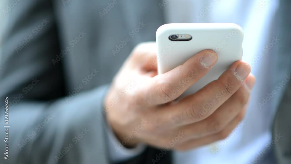 Closeup of a businessman using his smartphone outdoor