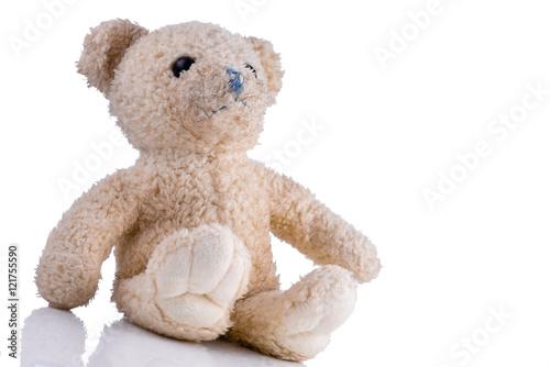 Dirty toy bear sitting isolated on white background