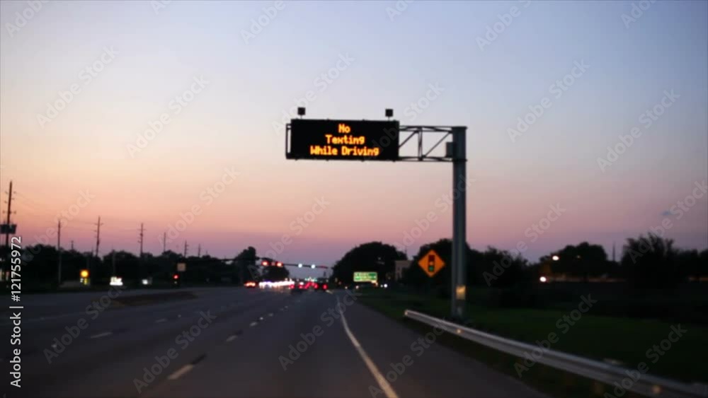 A warning sign on a busy stretch of road warns drivers not to text while they are driving.