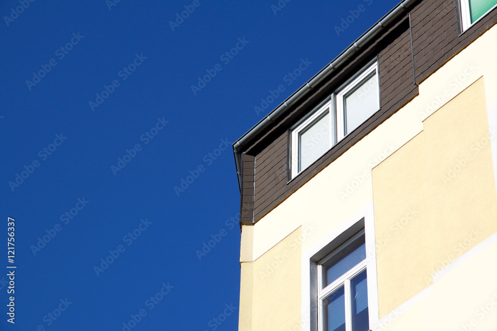 Corner of yellow house against a blue sky in Aachen, Germany