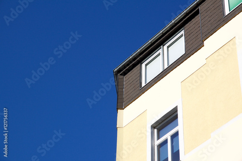 Corner of yellow house against a blue sky in Aachen, Germany