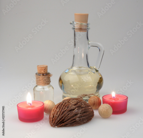 spa composition. scented candles, coffee beans, aromatic wooden balls and oil in a glass jug with a stopper.  partially tinted photo. photo