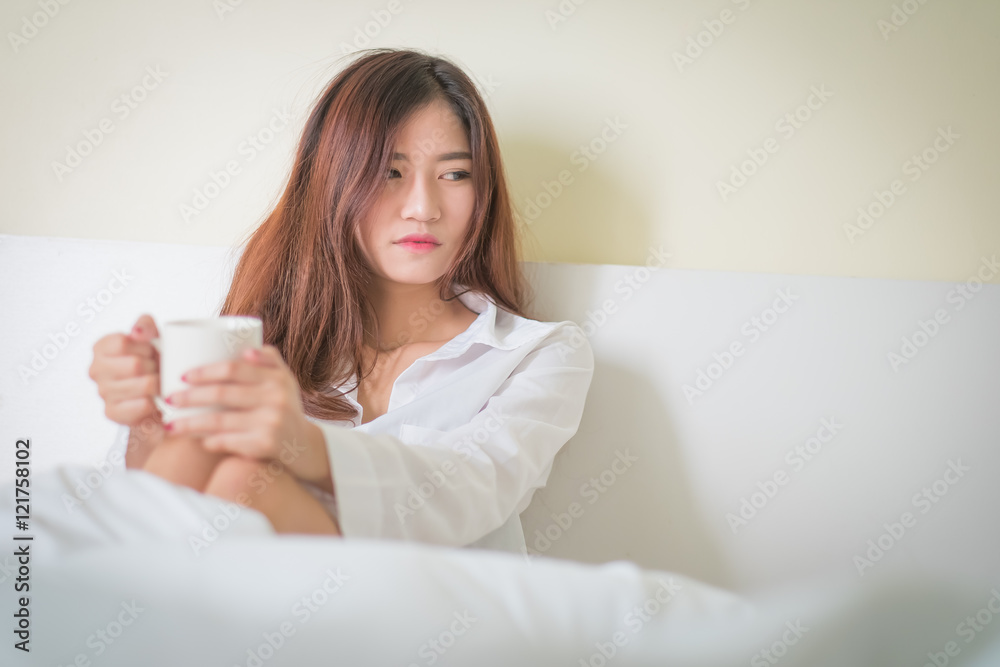 Beautiful brunette woman drinking and morning coffee in bedroom Beautiful brunette woman drinking and morning coffee in bedroom
