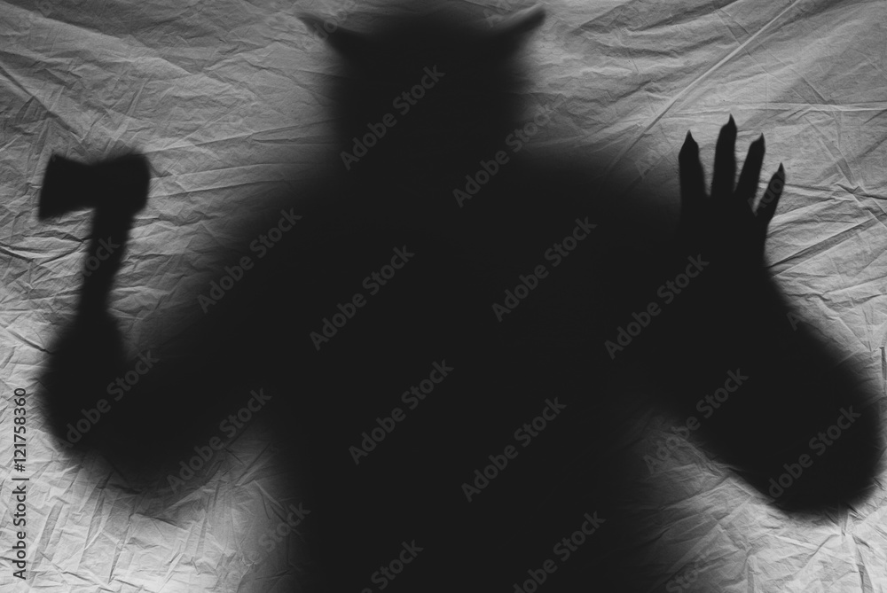 daemon silhouette with horns on a dark background
