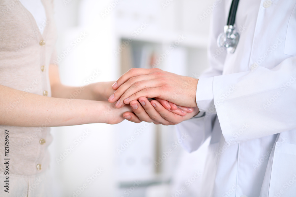 Hand of doctor reassuring her female patient