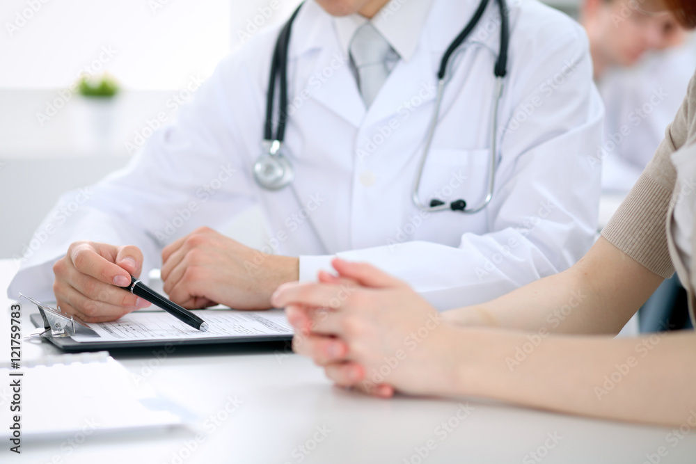Doctor and patient are discussing something, just hands at the table Doctor and patient are discussing something, just hands at the table