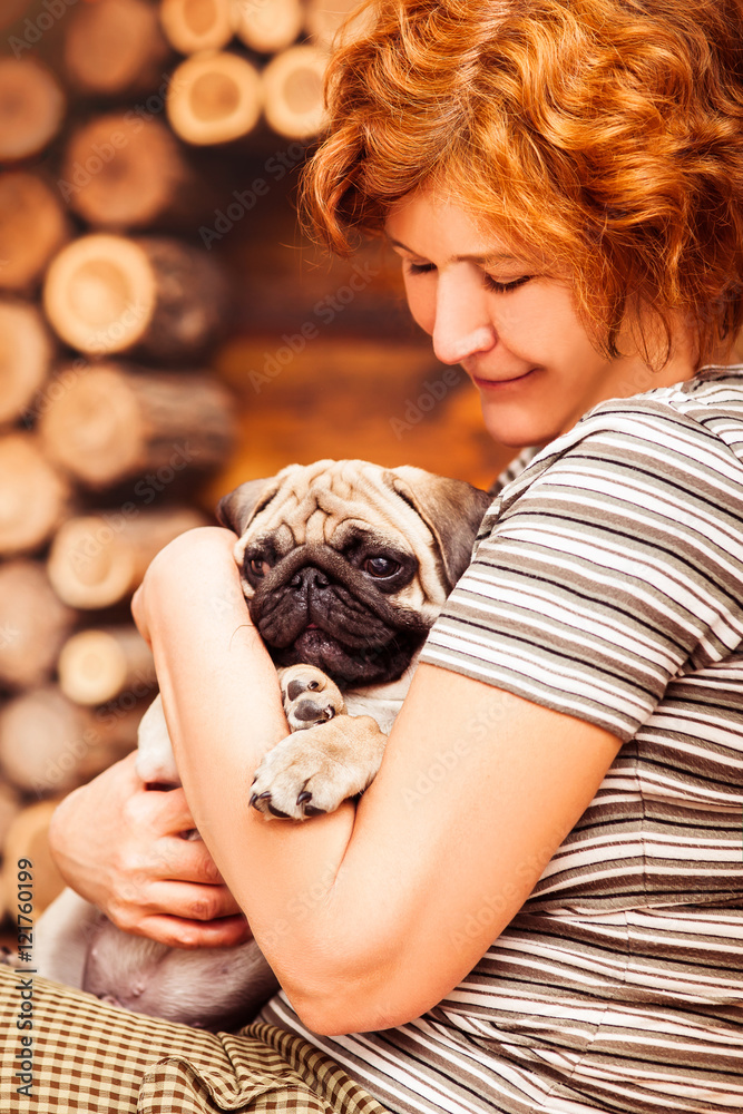 White puppy pug hiding on arms of loving owner White puppy pug hiding on arms of loving owner