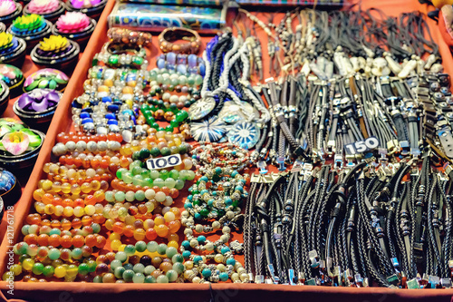 Rows of different leather bracelets,necklaces and other souvenirs at night market, Koh Chang, Thailand. Selective focus