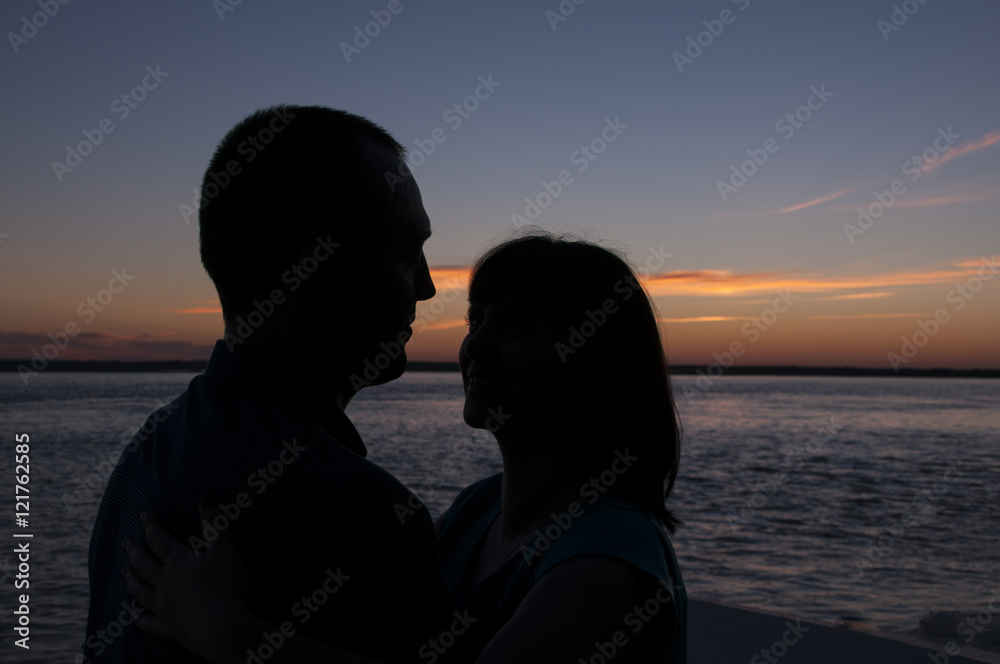 Silhouette of a couple on the sunset background  