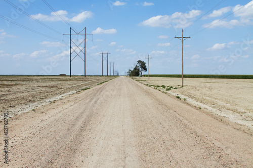 Dirt road and horizon with power lines and clouds