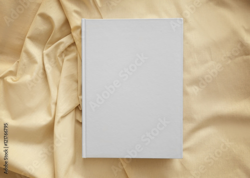 White closed book on light crumpled sheet