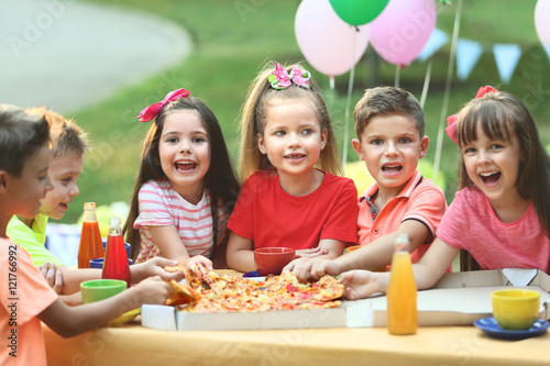 Children eating pizza in park
