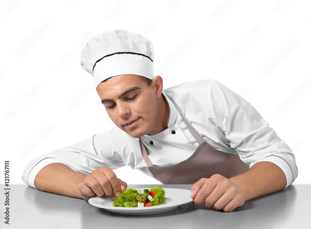 Young handsome chef cook making salad isolated on white Young handsome chef cook making salad isolated on white