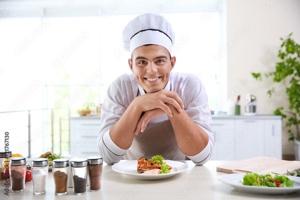 Young chef cook decorating meat dish in kitchen Young chef cook decorating meat dish in kitchen